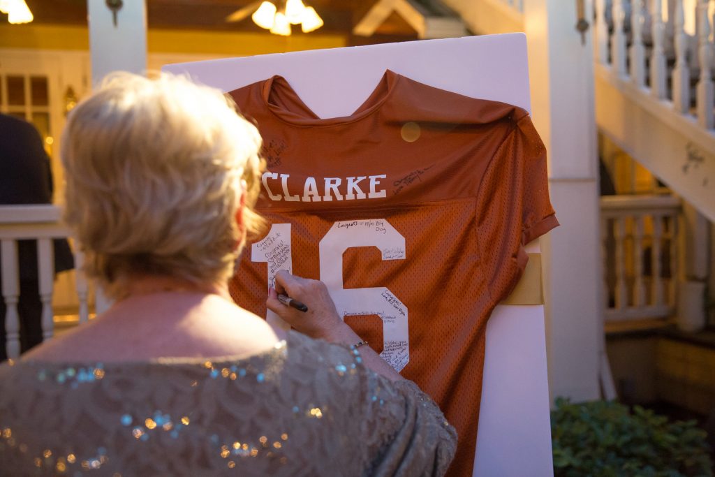 Football Jersey Guestbook Signing | The Courtyard at Lake Lucerne Classic Purple & Orange Wedding Football Texas Longhorns Sports Lake Lucerne Courtyard Anna Christine Events Orlando Kathy Thomas Photography
