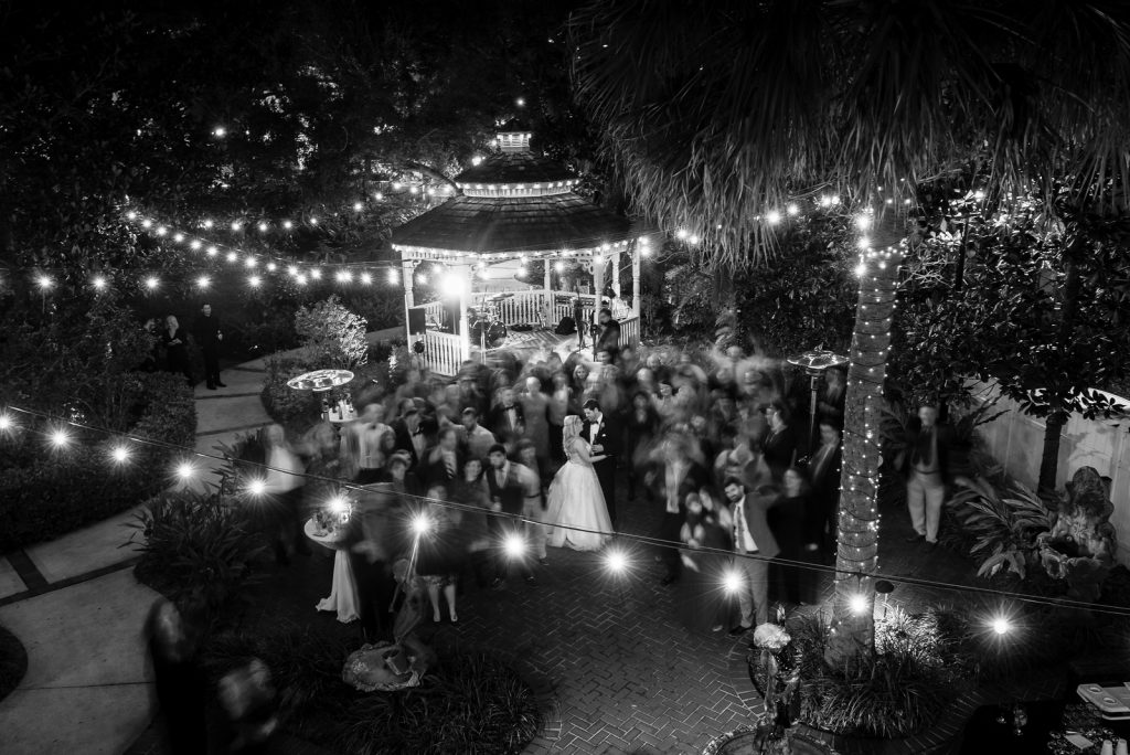 Bride & Groom Dancing Blurred Guests Reception | The Courtyard at Lake Lucerne Classic Purple & Orange Wedding Football Texas Longhorns Sports Lake Lucerne Courtyard Anna Christine Events Orlando Kathy Thomas Photography